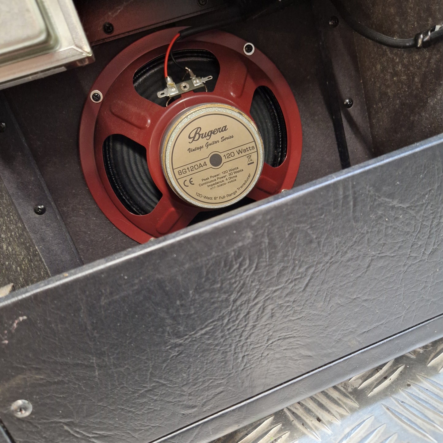 Pre-Owned Bugera Vintage 5 V5 Valve Guitar Combo A close-up shot of a red and beige Beyer Dynamic 911 speaker mounted inside a vehicle or machinery compartment, with a dark textured panel framing the shot.