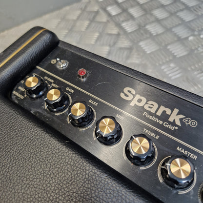Pre-Owned Positive Grid Spark 40-Watt Smart Guitar Combo & Bluetooth Speaker Close-up of a black Spark 40 Positive Grid guitar amplifier control panel with gold-tone knobs and white branding text.