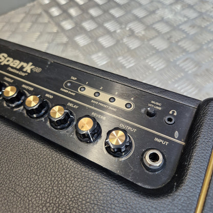 Pre-Owned Positive Grid Spark 40-Watt Smart Guitar Combo & Bluetooth Speaker Close-up of the control panel of a black Spark 200 guitar amplifier, showing knobs for volume, bass, mid, treble, feedback, and gain, alongside input and output jacks, set against a textured black leather body.
