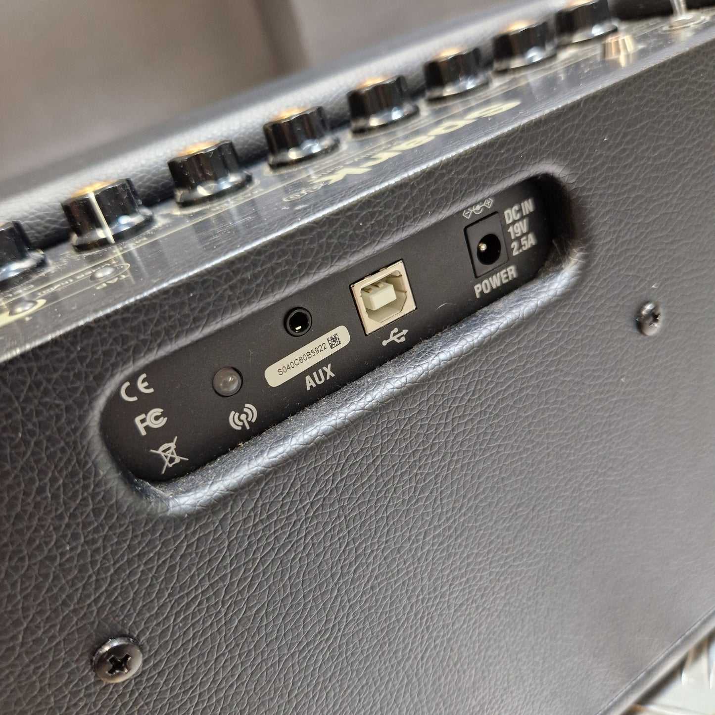 Pre-Owned Positive Grid Spark 40-Watt Smart Guitar Combo & Bluetooth Speaker Close-up of the rear or side control panel of a black guitar amplifier, showing input jacks, volume knobs, and labels including POWER, AUX, and INPUT.