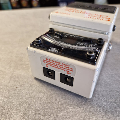 Pre-Owned Boss TU-3 Tuner Pedal A vintage-style guitar effects pedal or modulation stage unit with a white metal casing, black front panel, rotary controls, and warning labels, photographed on a gray textured surface.