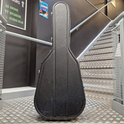 Pre-Owned Hiscox LiteFlite Acoustic Hard Case A black hard guitar case standing upright on a metal staircase landing in an indoor studio or building setting.