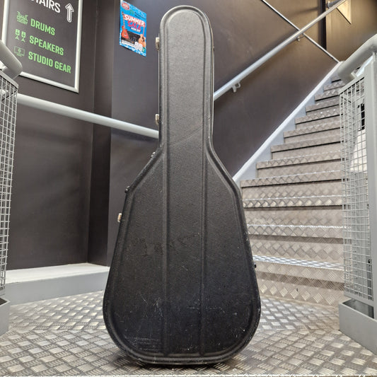 Pre-Owned Hiscox LiteFlite Acoustic Hard Case A black hard guitar case standing upright on a metal staircase landing in an indoor studio or building setting.