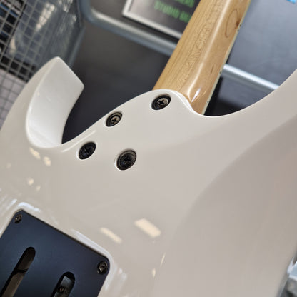Pre-Owned Ibanez RG350DX Electric - White Close-up of a white electric guitar body showing the control hole, screws, black pickup cover, and part of the natural wood neck.