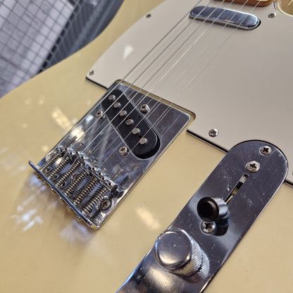 Pre-Owned Squier MIK 1996 Telecaster Electric - Blonde Close-up of a cream-colored electric guitar body showing the chrome bridge, pickups, control plate, and part of the white pickguard.