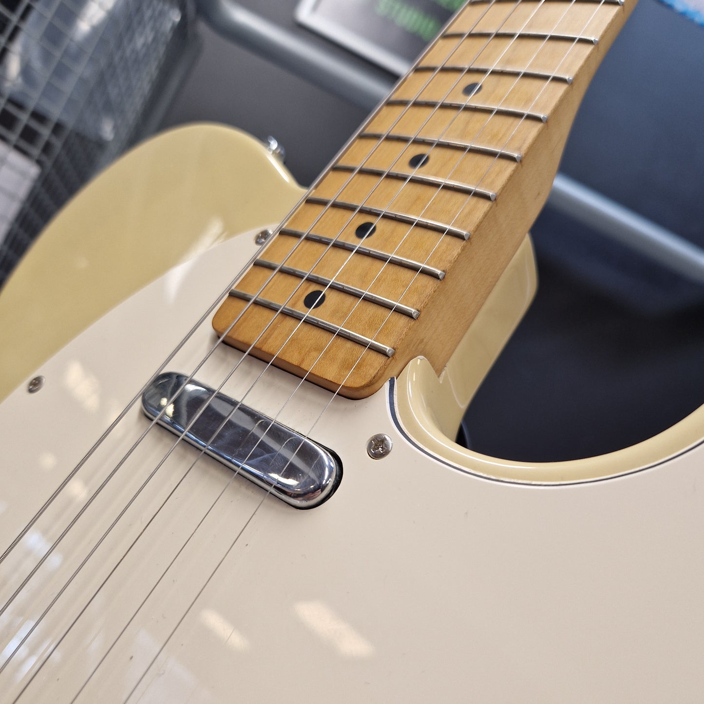 Pre-Owned Squier MIK 1996 Telecaster Electric - Blonde Close-up of a cream-colored electric guitar body with a natural wood fretboard and silver hardware.