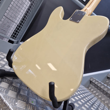 Pre-Owned Squier MIK 1996 Telecaster Electric - Blonde Close-up of the back of a glossy cream-colored electric guitar resting on a black stand over a diamond plate floor.