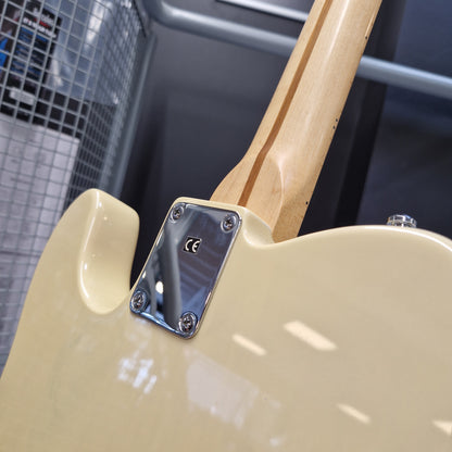 Pre-Owned Squier MIK 1996 Telecaster Electric - Blonde Close-up of the rear body of a cream-colored electric guitar with a natural wood neck and a chrome hardware plate, set against a dark gray industrial background.