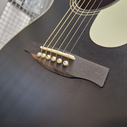 Pre-Owned PRS P20 Tonare Parlor Electro-Acoustic - Black Close-up detail of an acoustic guitar's bridge, showing six ivory-colored round tuning pegs on a dark wood bridge plate over a matte black body.