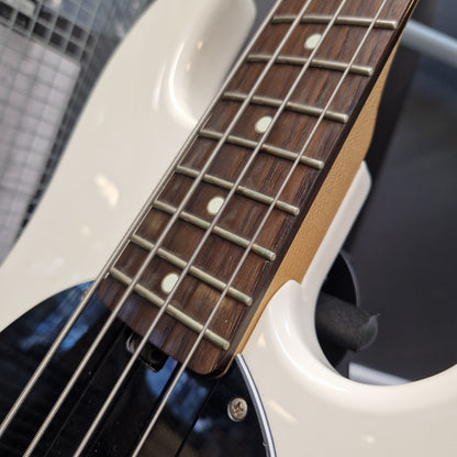 Pre-Owned Music Man Sterling Sub Series Ray 4 Bass - White Close-up of a bass guitar neck with a dark wood fretboard, silver metal frets, and a white body with a black pickguard.