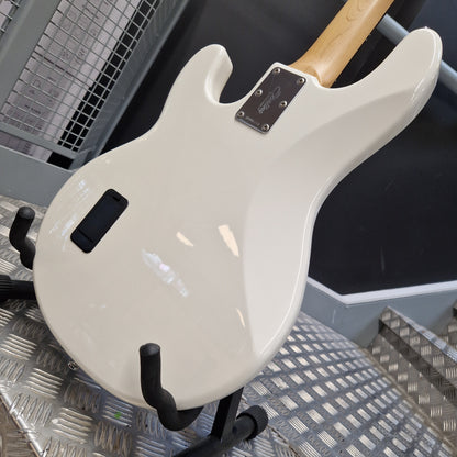 Pre-Owned Music Man Sterling Sub Series Ray 4 Bass - White A close-up of the glossy cream-colored back of an electric guitar body, resting on a black stand on a metal diamond plate floor. The neck shows a natural light wood finish.