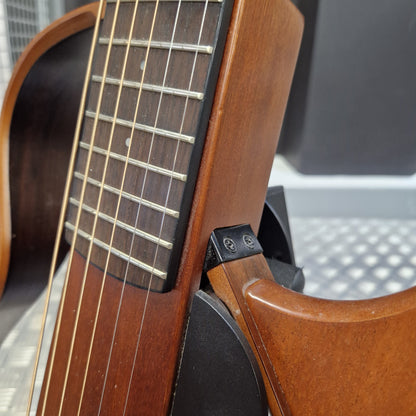 Pre-Owned Yamaha SLG200S Silent Guitar Electro-Acoustic - Natural Close-up detail of a wooden acoustic guitar showing the fingerboard, strings, side edge, and part of the body in warm brown tones.