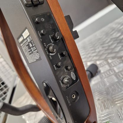 Pre-Owned Yamaha SLG200S Silent Guitar Electro-Acoustic - Natural Close-up of the control panel of a Yamaha speaker, showing various knobs and labels like PA, RELAY, MUTE, and SPEAKER, mounted on a wooden structure over a diamond plate metal floor.