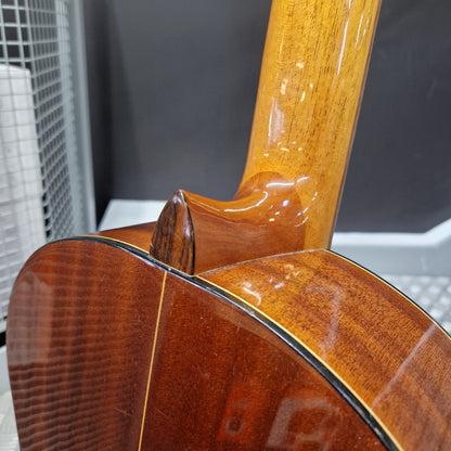 Pre-Owned Admira Solista Classical - Natural Close-up detail of the back and neck of an acoustic guitar, showing the glossy wood grain, sound hole, and binding against a dark gray background.