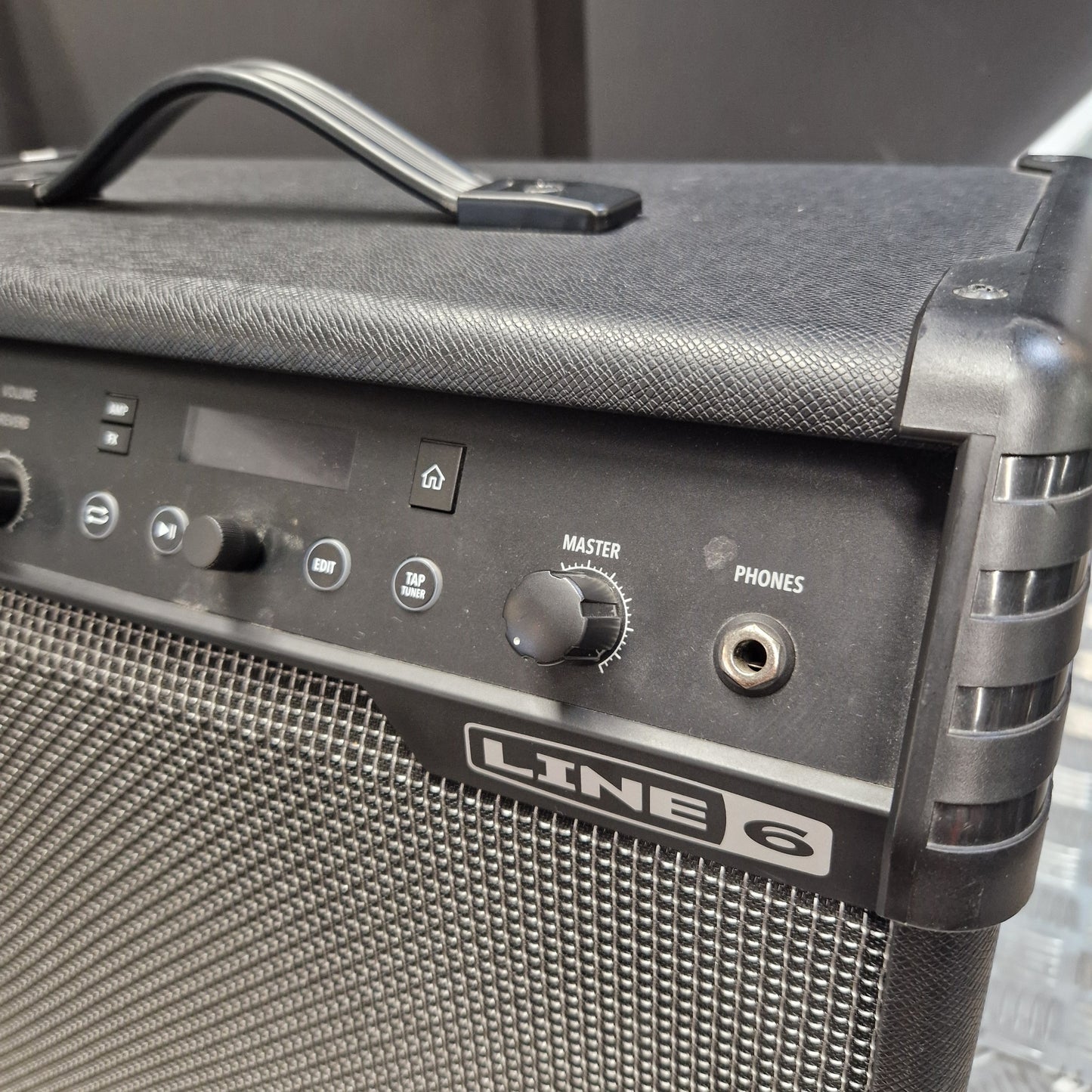 Pre-Owned Line 6 Spider V 120 Mk II Guitar Combo Amplifier Close-up of a black Line 6 portable guitar amplifier showing the front control panel with knobs, a handle on top, and the Line 6 logo on the grille.