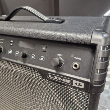 Pre-Owned Line 6 Spider V 120 Mk II Guitar Combo Amplifier Close-up of a black Line 6 portable guitar amplifier showing the front control panel with knobs, a handle on top, and the Line 6 logo on the grille.