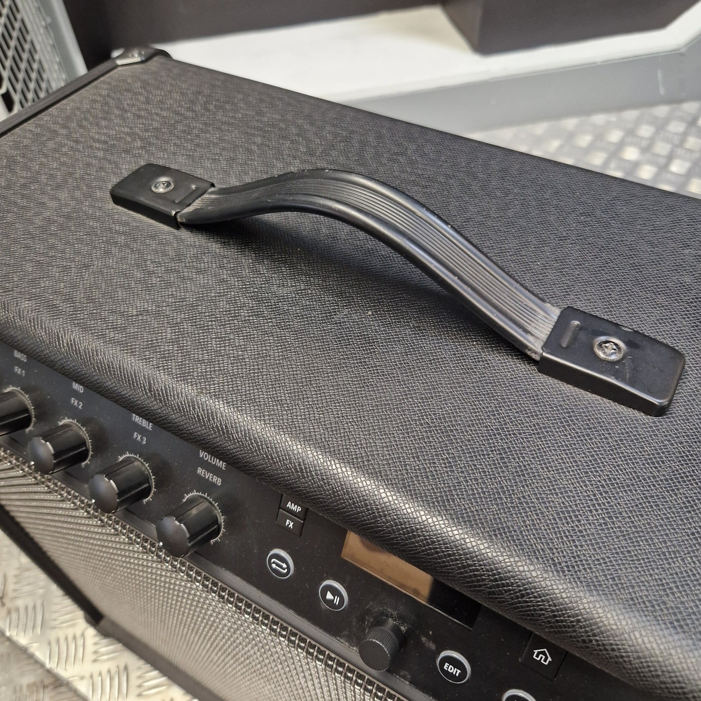 Pre-Owned Line 6 Spider V 120 Mk II Guitar Combo Amplifier Close-up of a black guitar amplifier handle with a textured gray fabric cover, mounted on the top of a speaker cabinet.