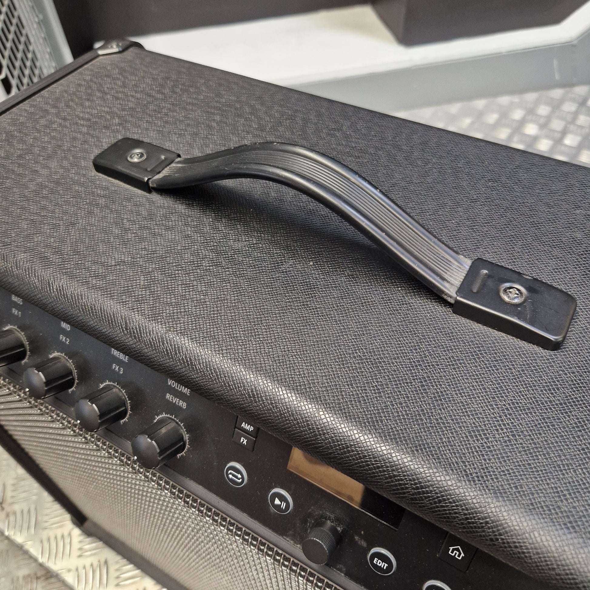 Pre-Owned Line 6 Spider V 120 Mk II Guitar Combo Amplifier Close-up of a black guitar amplifier handle with a textured gray fabric cover, mounted on the top of a speaker cabinet.