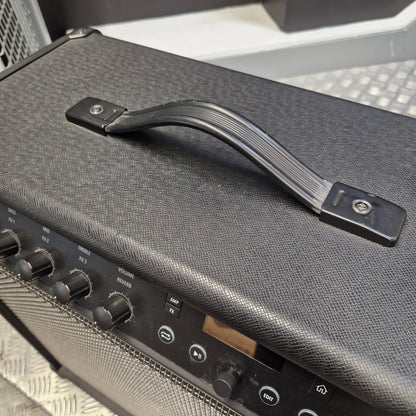 Pre-Owned Line 6 Spider V 120 Mk II Guitar Combo Amplifier Close-up of a black guitar amplifier handle with a textured gray fabric cover, mounted on the top of a speaker cabinet.