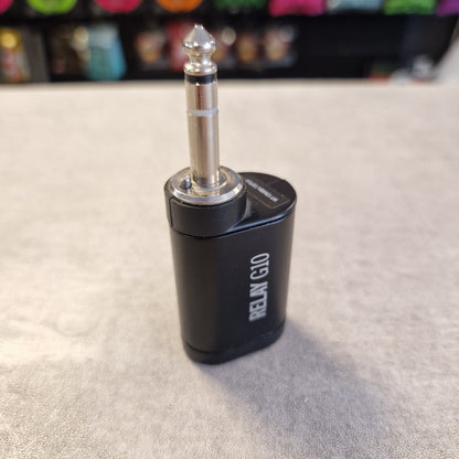 Pre-Owned Line 6 Spider V 120 Mk II Guitar Combo Amplifier A black RELN G10 audio adapter with a silver 1/4-inch jack plug, standing on a gray textured surface with a blurred background.