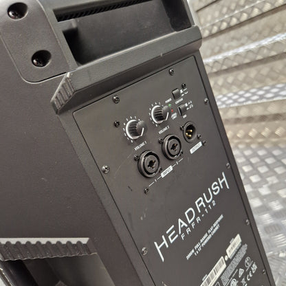 Pre-Owned Headrush FRFR-112 Full Range Powered 1x12 Speaker Close-up of the rear control panel of a black Headrush FRA-112 portable speaker, showing volume and audio 1/2 controls, on a diamond plate metal surface.