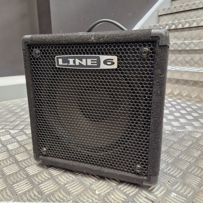Pre-Owned Line 6 LowDown Studio 110 75w Digital Bass Combo A black Line 6 guitar amplifier with a front mesh grille and a visible 'LINE 6' logo plate, photographed on a metal diamond-plate surface with stairs in the background.
