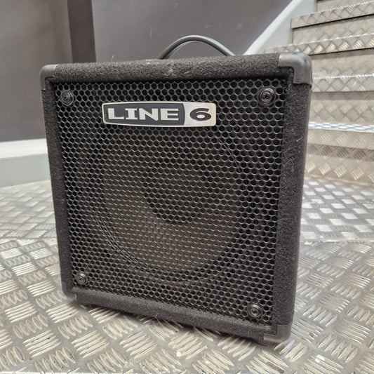 Pre-Owned Line 6 LowDown Studio 110 75w Digital Bass Combo A black Line 6 guitar amplifier with a front mesh grille and a visible 'LINE 6' logo plate, photographed on a metal diamond-plate surface with stairs in the background.