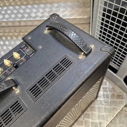 Pre-Owned Vox VT100 Valvetronix 100w Electric Combo Close-up of the top and side of a black textured guitar amplifier head with control knobs, vent grilles, and a handle, photographed on a metal diamond-plate floor.