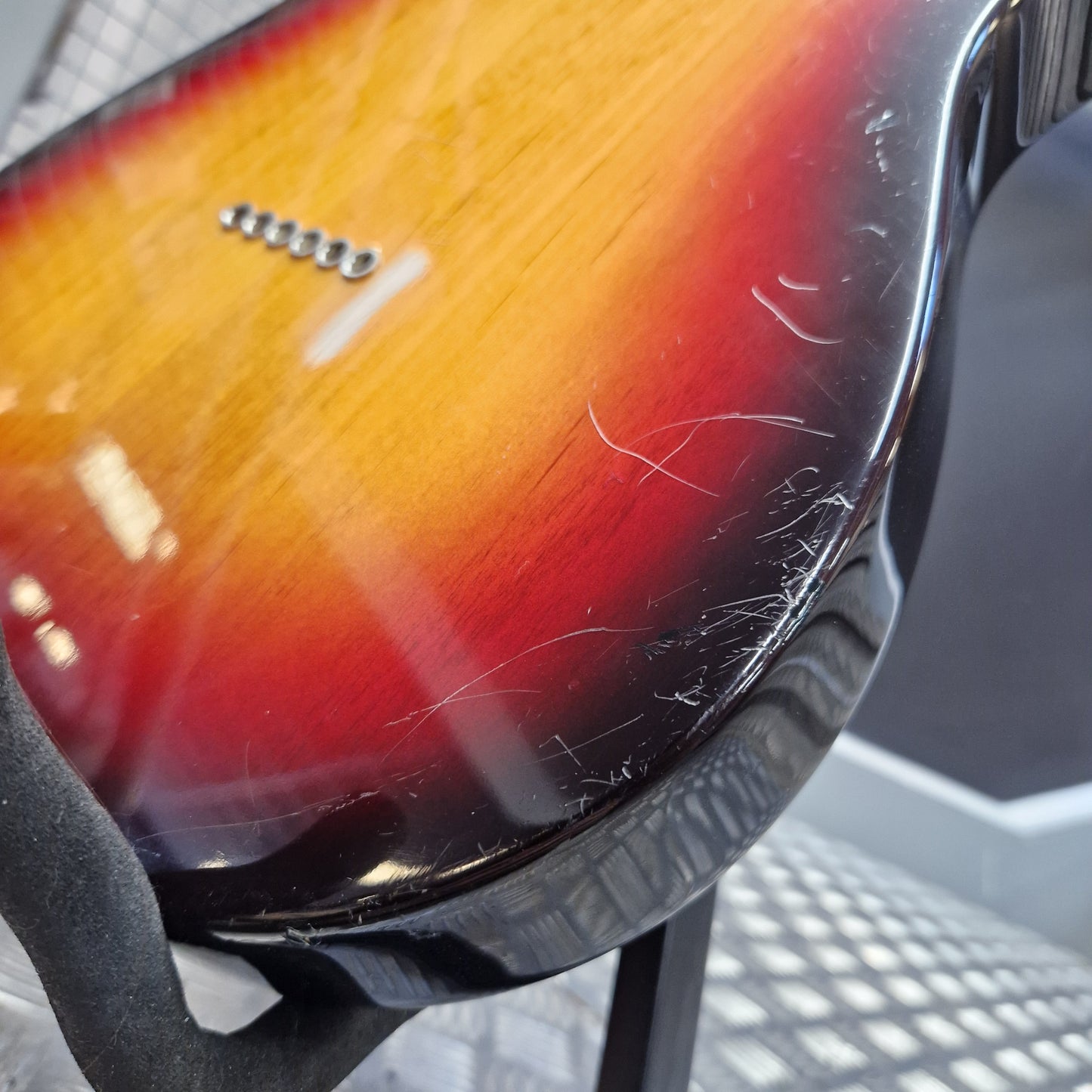 Pre-Owned Fender American Standard Telecaster 2000 Electric - 3-Colour Sunburst Close-up of the back of a sunburst electric guitar showing a glossy yellow-to-red gradient finish with visible scratches on the glossy surface.