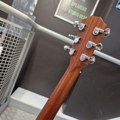 Pre-Owned Taylor GS Mini-e Electro-Acoustic - Limited Edition Quilted Sapele Close-up of the headstock of a wooden acoustic guitar, showing six silver tuning pegs and tuners against a dark gray background.