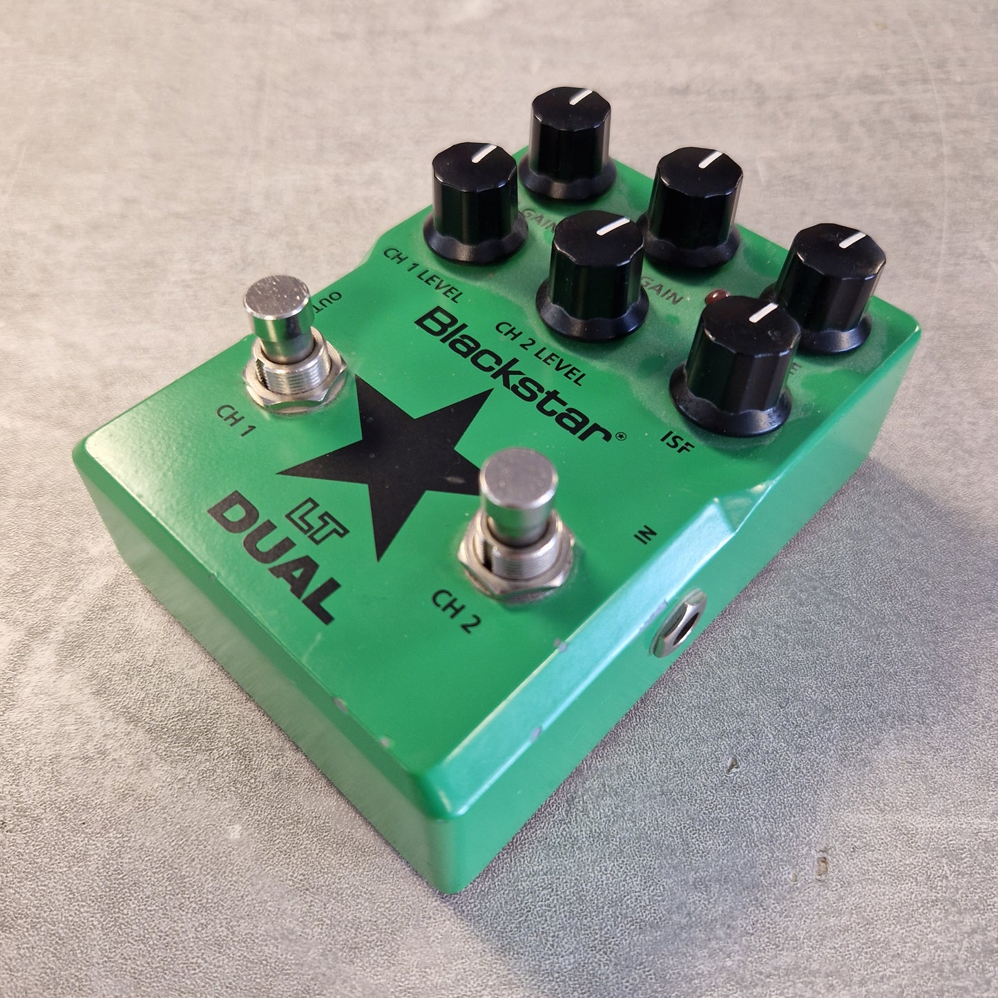 Pre-Owned Blackstar LT-DUAL Two-Channel Distortion Pedal A green Leslie Dual Blackstar guitar effects pedal with six black knobs, two silver footswitches, and white text, photographed on a gray textured surface.