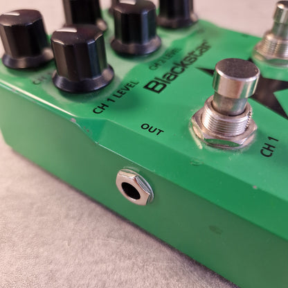 Pre-Owned Blackstar LT-DUAL Two-Channel Distortion Pedal Close-up of a green Blackstar guitar effects pedal with black knobs, a silver footswitch, and a 1/4-inch input jack on a gray textured surface.