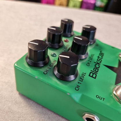 Pre-Owned Blackstar LT-DUAL Two-Channel Distortion Pedal A close-up of a green Blackstar Chopper effects pedal with black knobs, showing the CH1 Gain, CH2 Gain, CH1 Level, and CH2 Level controls on a light gray textured surface.