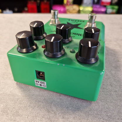 Pre-Owned Blackstar LT-DUAL Two-Channel Distortion Pedal A green dual channel audio effects pedal with six black knobs, silver metal footswitches, and a 9V DC power jack, shown on a gray textured surface.