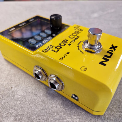 Pre-Owned Nux Loop Core Stereo Looper Pedal A close-up of a yellow NUX Loop Core Stereo guitar effects pedal on a textured gray surface. The pedal features a black control display, black knobs, silver jacks, and a prominent silver footswitch.