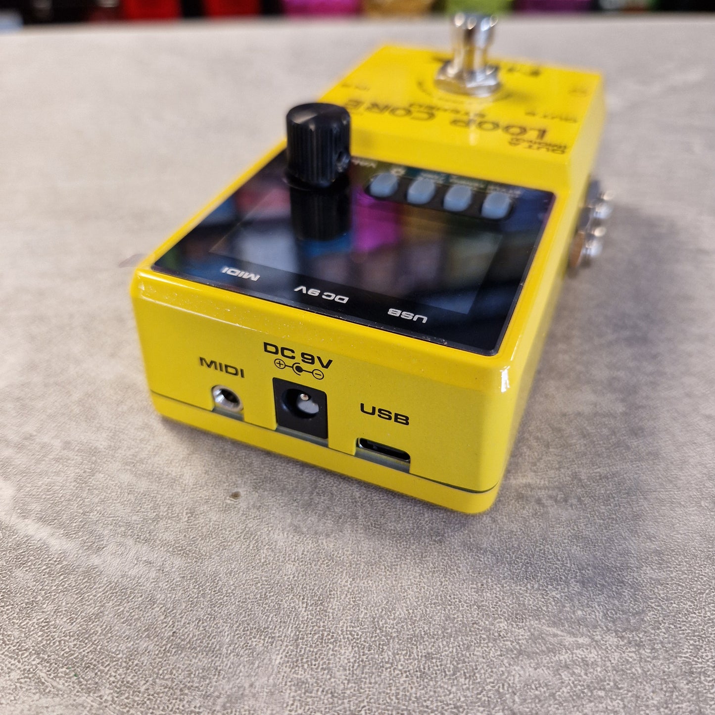 Pre-Owned Nux Loop Core Stereo Looper Pedal A yellow Boss effects pedal, model BS-205, with a black display screen, black rotary knob, and various input/output jacks, resting on a gray textured surface.