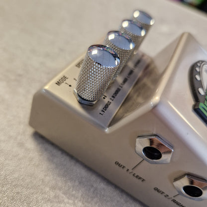 Pre-Owned Marshall RG1 Regenerator Modulation Pedal Close-up of a beige guitar effects pedal with four shiny silver control knobs and metal input/output jacks on a light fabric surface.