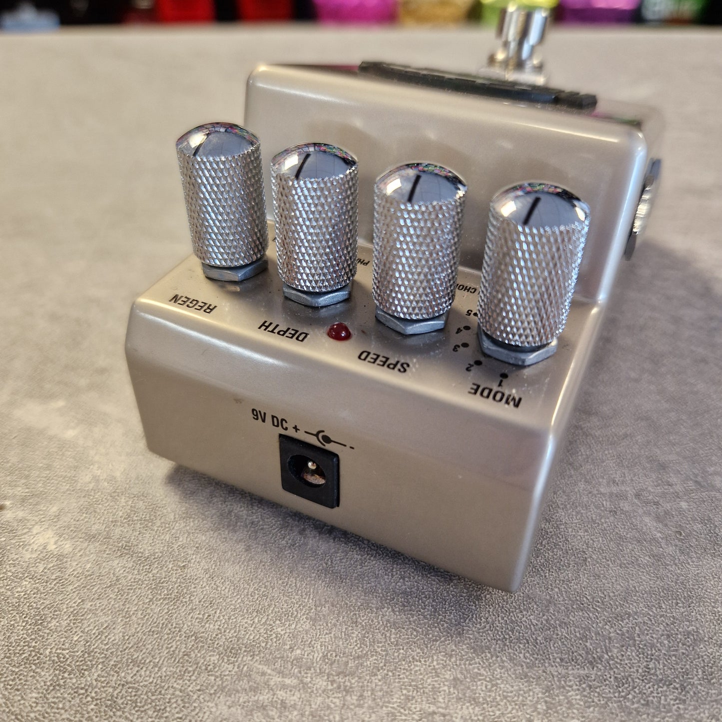 Pre-Owned Marshall RG1 Regenerator Modulation Pedal A silver metal guitar effects pedal with four knurled silver control knobs labeled Reverb, Depth, Speed, and Mode, shown on a gray textured surface.