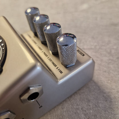 Pre-Owned Marshall RG1 Regenerator Modulation Pedal A close-up of a silver metal guitar effects pedal with four knurled chrome control knobs and printed text reading 'MAGNEZ'.