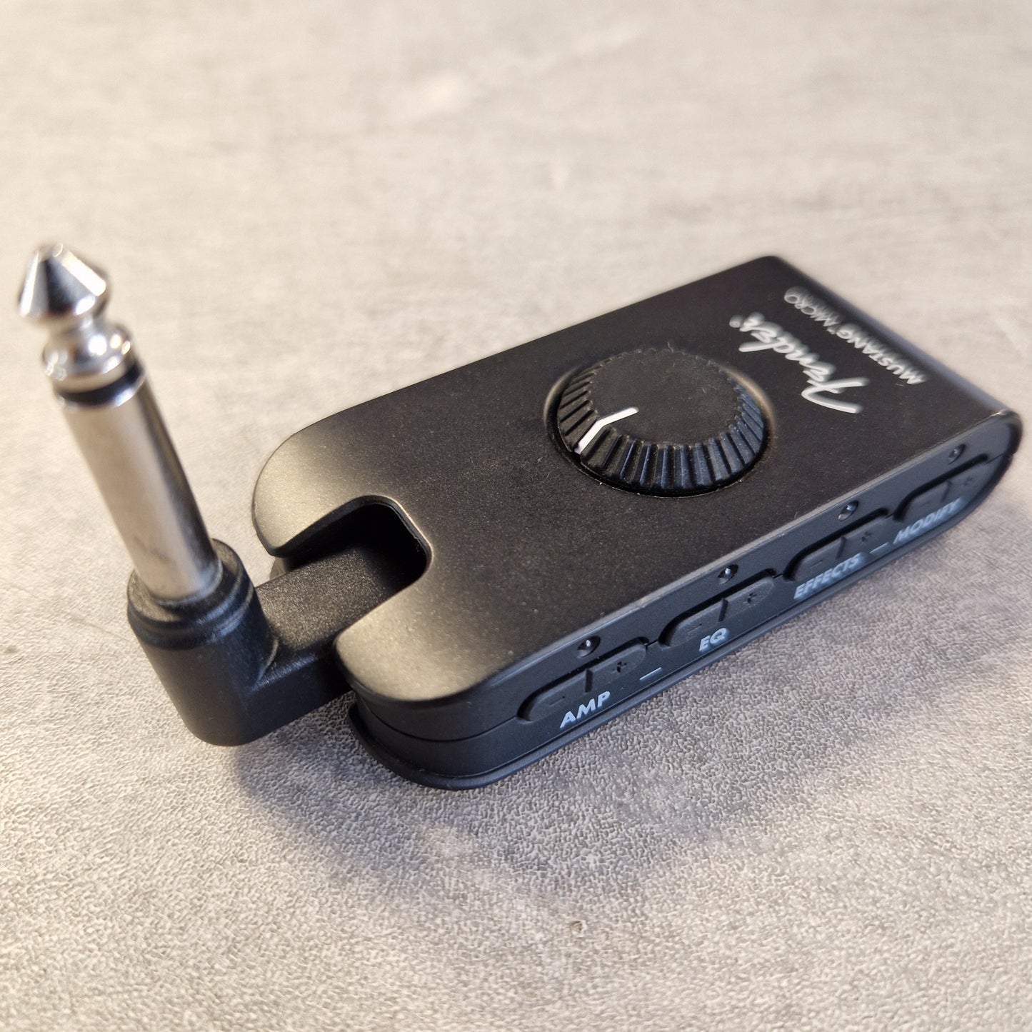 Pre-Owned Fender Mustang Micro Headphone Guitar Amplifier A black Fender Wah-Wah2 wireless guitar effects pedal with a 1/4-inch jack connector, resting on a textured gray surface.