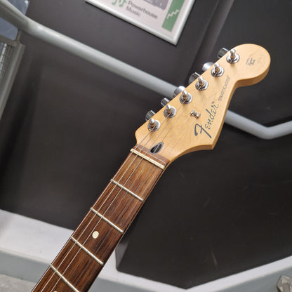 Pre-Owned Fender Standard Mexican Stratocaster 2011 Electric - Black Close-up of a Fender electric guitar headstock and upper neck, showing the natural wood headstock, six silver tuning pegs, and dark brown fretboard against a dark gray background.