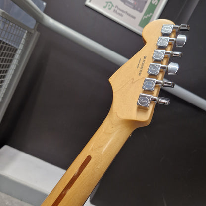 Pre-Owned Fender Standard Mexican Stratocaster 2011 Electric - Black Close-up of the headstock and neck of a Fender electric guitar in a natural maple finish, showing six silver tuning pegs and the Fender logo on the headstock.