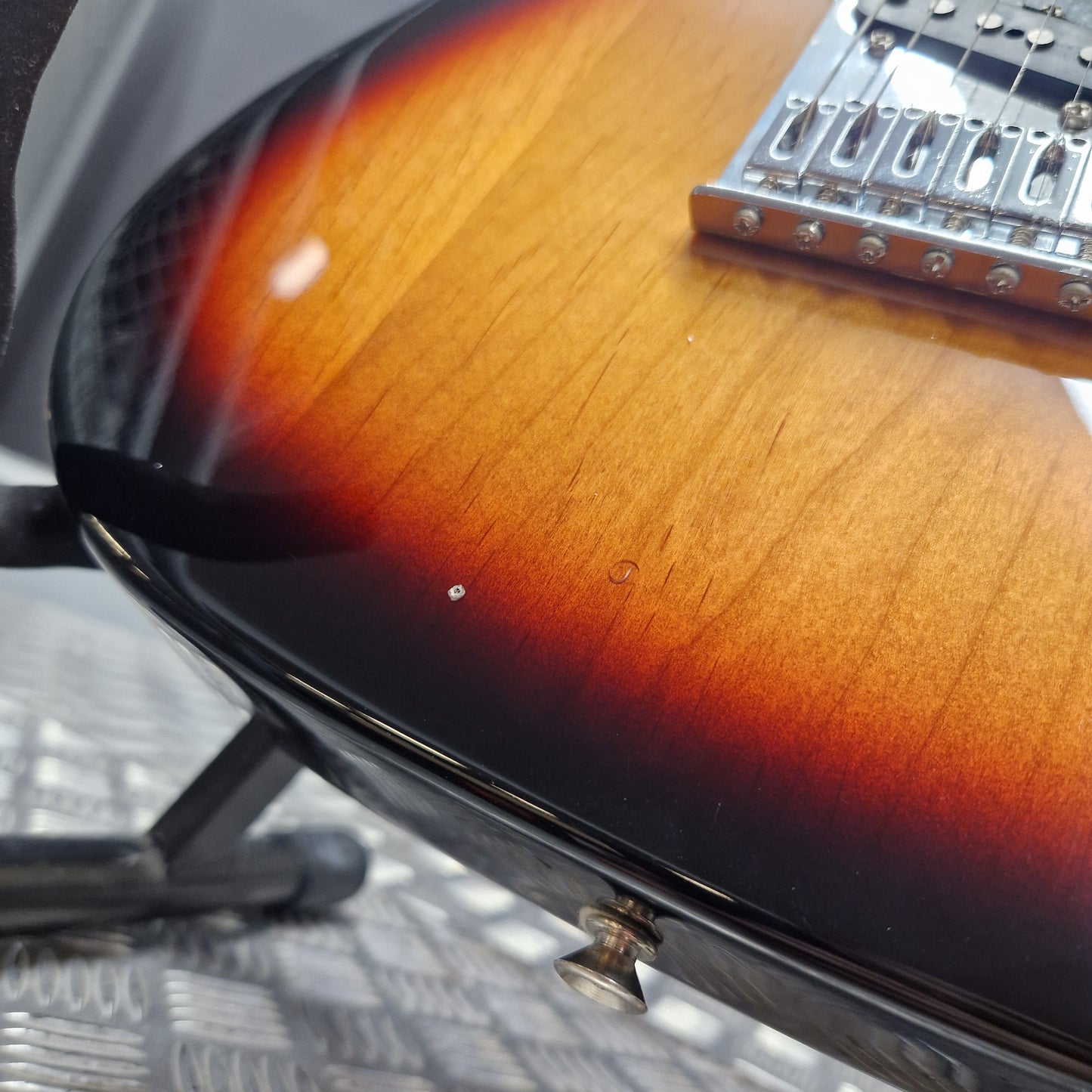 Pre-Owned Fender Player Telecaster 2022 Electric - 3-Colour Sunburst Close-up of a sunburst electric guitar body showing the glossy black edge, warm amber-to-brown gradient, wood grain, and part of the chrome bridge.