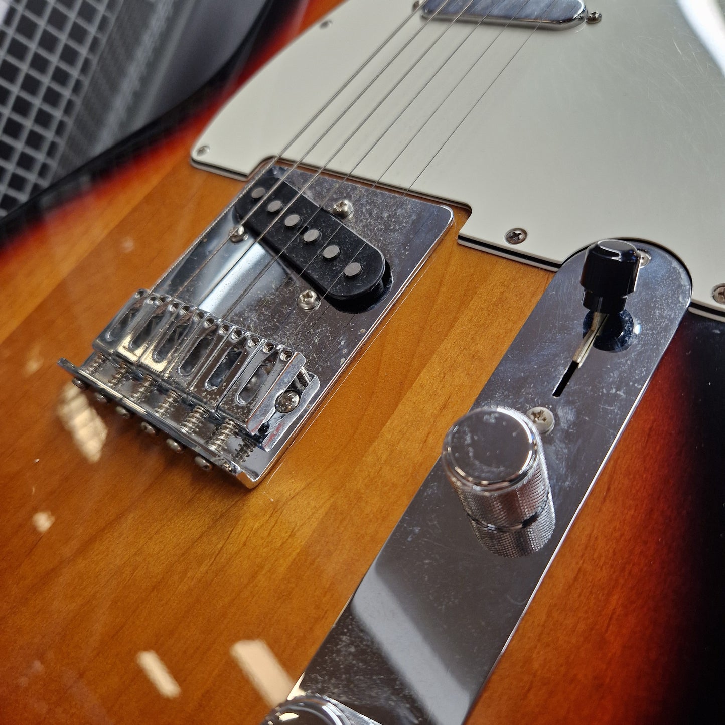 Pre-Owned Fender Player Telecaster 2022 Electric - 3-Colour Sunburst Close-up of a sunburst electric guitar body showing the bridge, pickups, control plate, and volume knob.