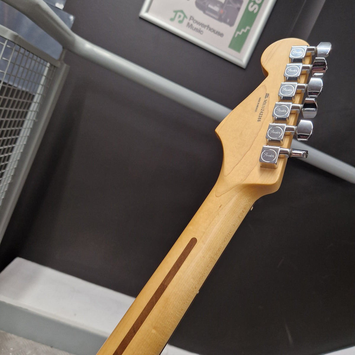 Pre-Owned Fender Standard Strocaster 2014 Electric - Arctic White Close-up of the headstock and neck of a Fender Stratocaster electric guitar, showing the maple wood neck, six chrome tuners, and the Fender logo on the headstock.