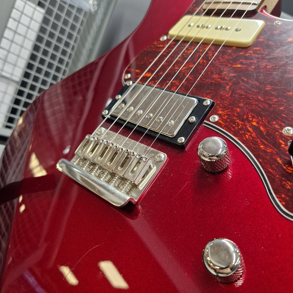 Pre-Owned Yamaha Pacifica 311H Electric - Red Metallic Close-up of a red electric guitar body showing the bridge, pickups, control knobs, and part of the neck on a neutral background.