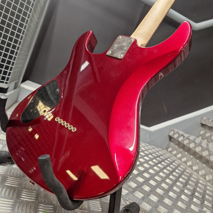 Pre-Owned Yamaha Pacifica 311H Electric - Red Metallic A glossy red electric guitar body shown from the back, mounted on a stand in a workshop or studio setting with a metal diamond-plate floor and dark background.