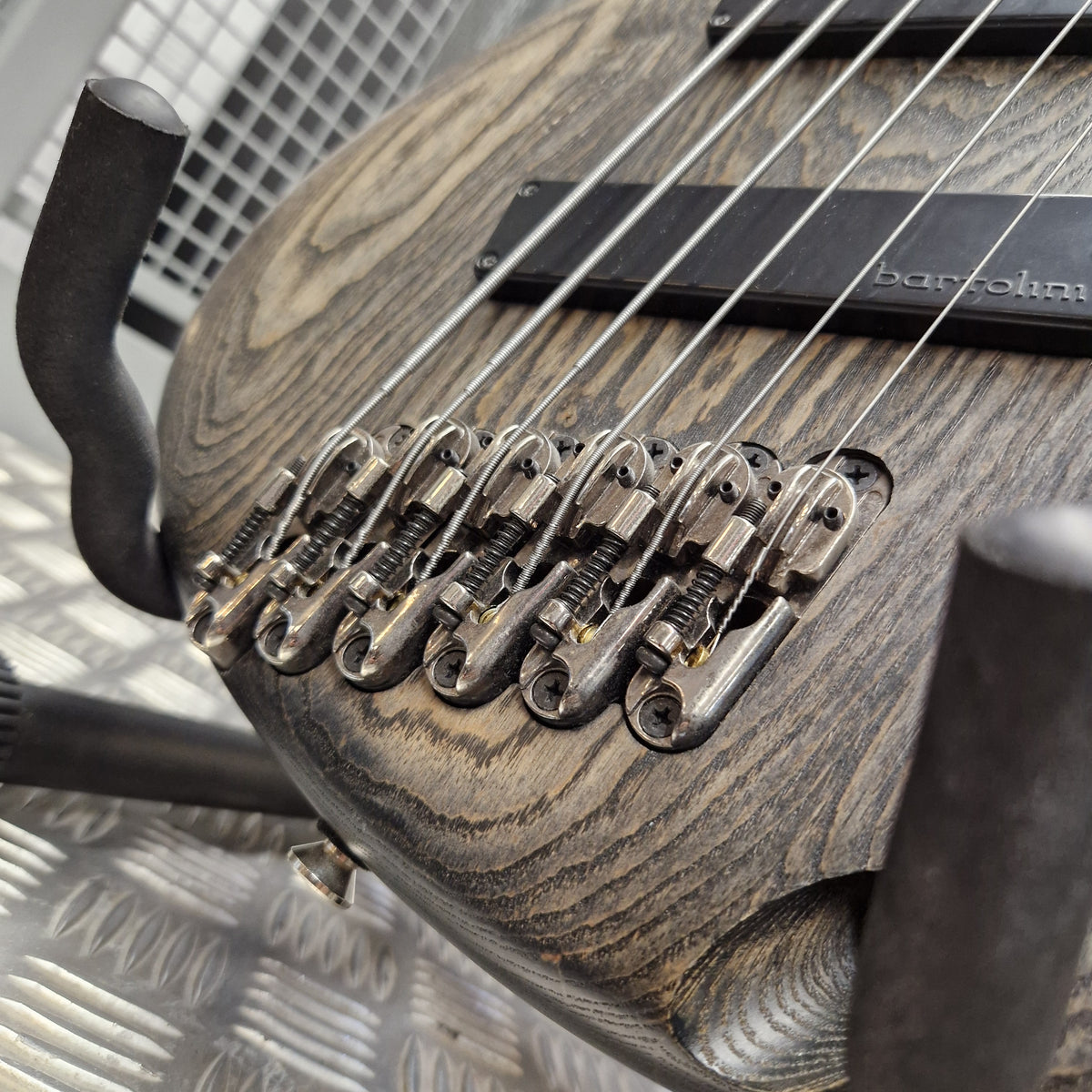 Pre-Owned Ibanez SRFF806 Multi-Scale 6-String Bass - Black Stained Close-up of a double-cutaway bass guitar with a dark, distressed wood finish and black hardware, including a visible Bartolomeo headstock.