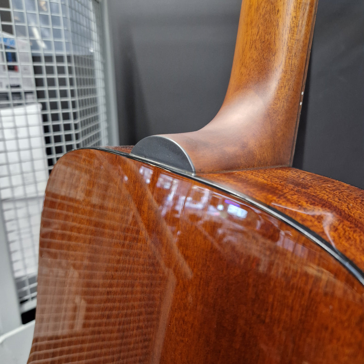Pre-Owned Guild D-125-12NAT Dreadnought 12-String Acoustic - Mahogany Close-up detail of an acoustic guitar's sound hole and upper bout, showcasing the glossy brown wood grain finish and a black rubber gasket.