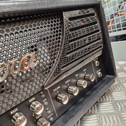 Pre-Owned Bugera 333XL Infinium 120w Electric Amplifer Head Close-up of a black guitar amplifier head with silver controls, a perforated metal grille, and a curved vented grille, photographed on a diamond plate metal surface.